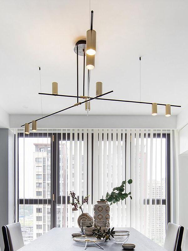 Crossed-bar chandelier over a table beside tall windows