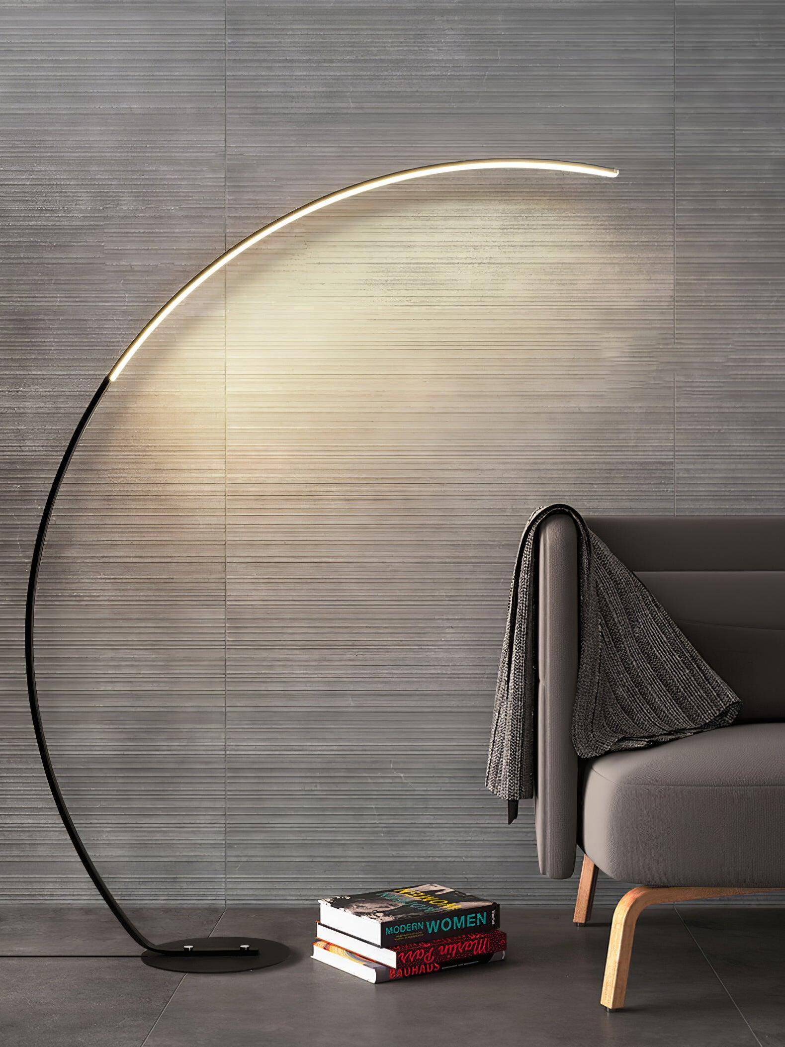 Black arc floor lamp beside grey chair