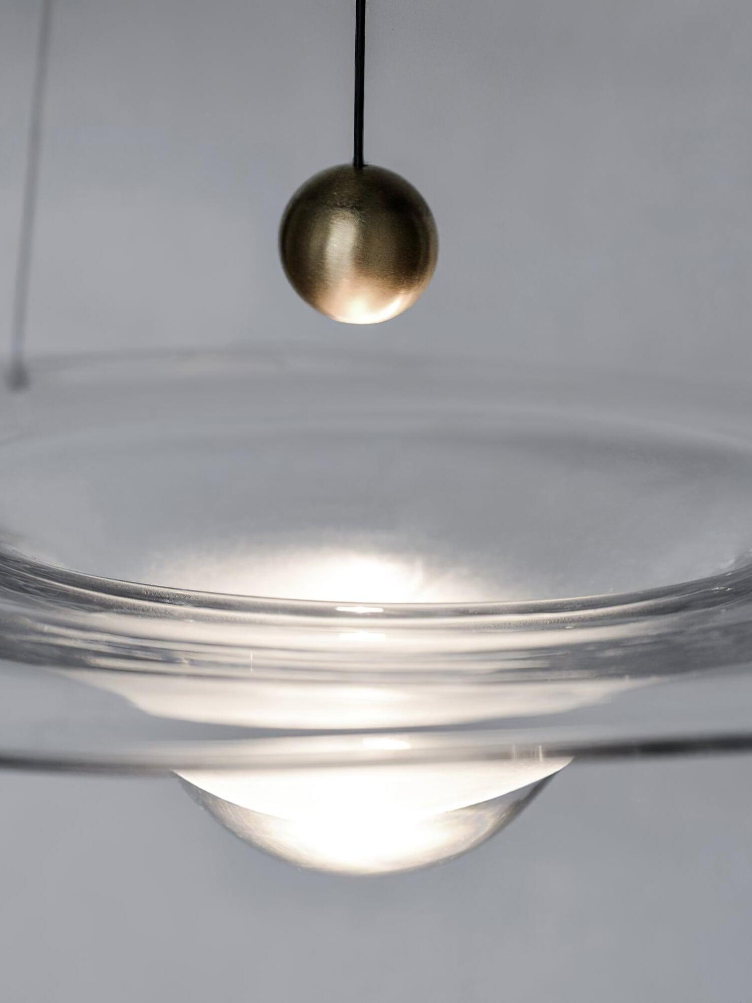 Close side view of brass ball and glowing glass bowl
