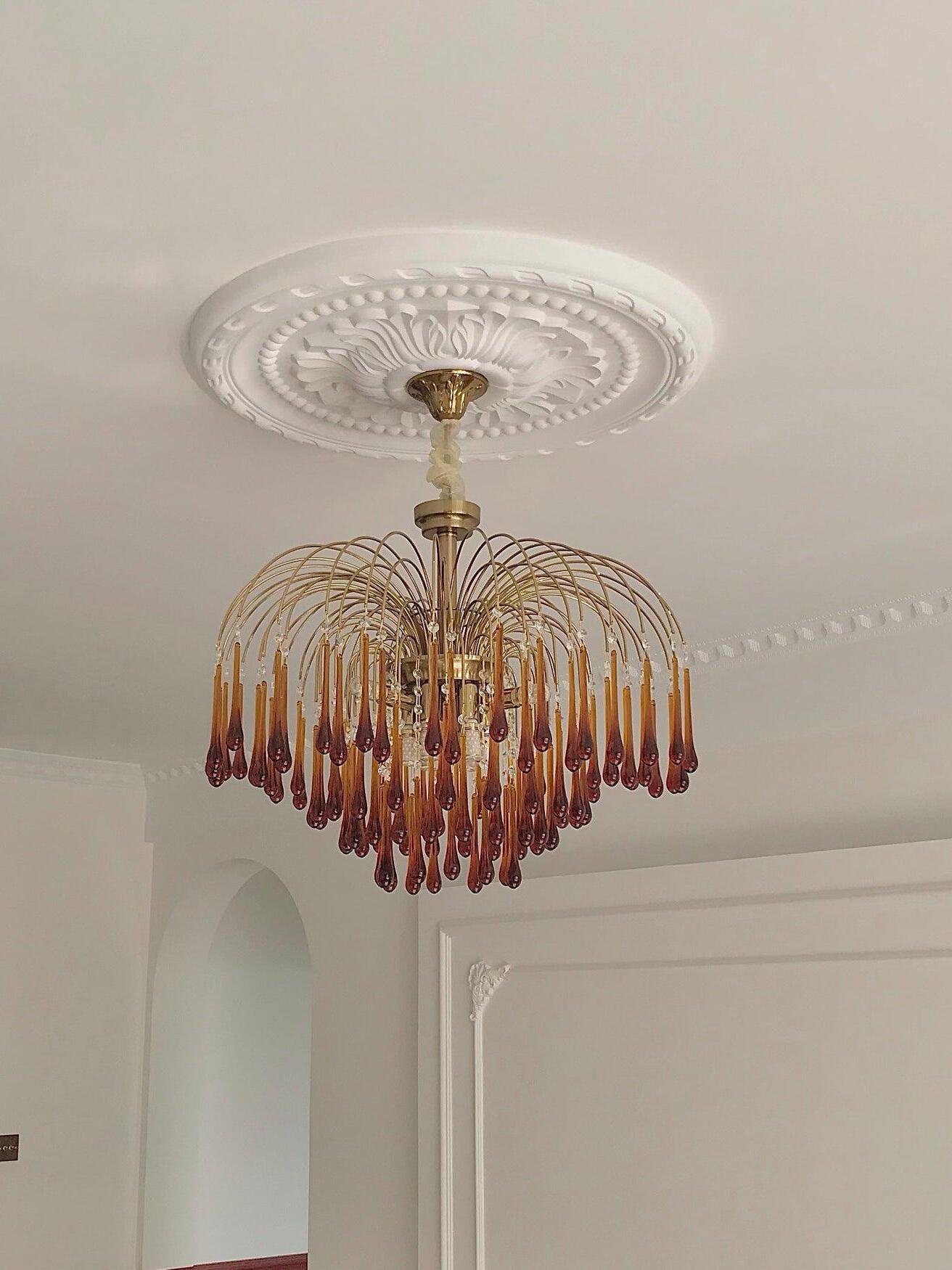 Wide Caramel chandelier beneath a ceiling medallion