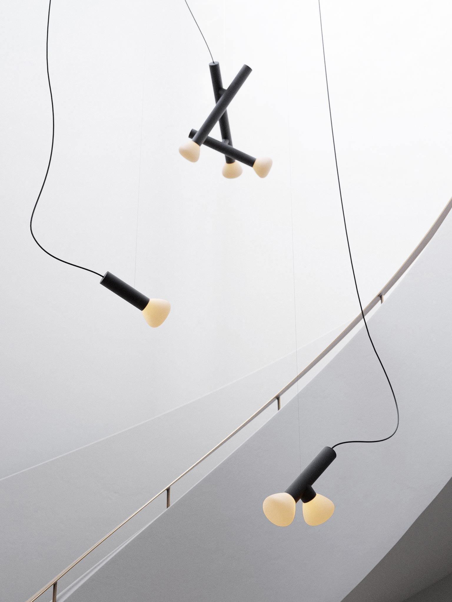 Black pendants hanging at varied heights in a stairwell
