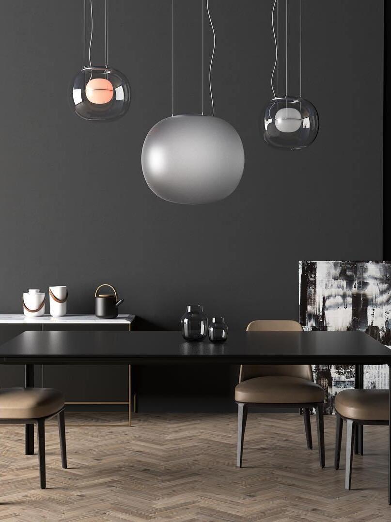 Glass globe pendants above a dark dining space