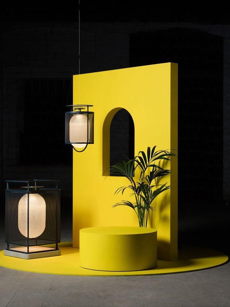 Black hanging and standing lanterns against yellow wall