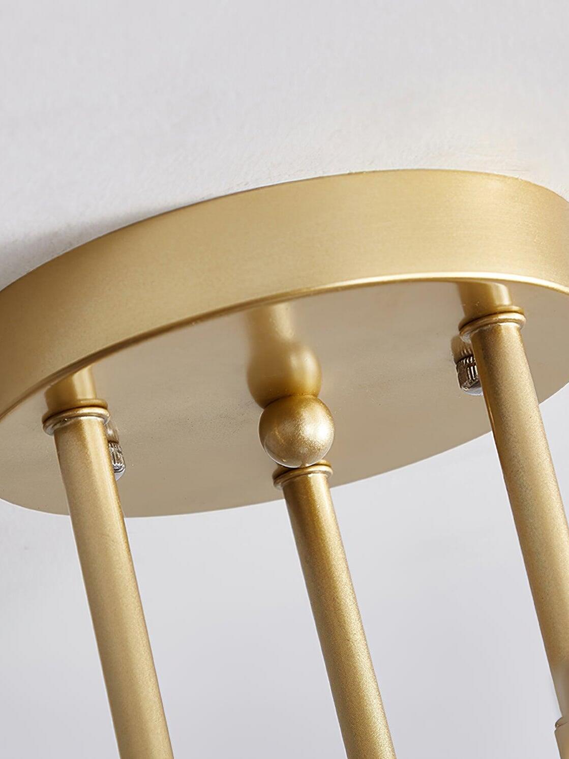 Macro view of the gold ceiling canopy, three descending stems, decorative central beads and silver-colored fasteners