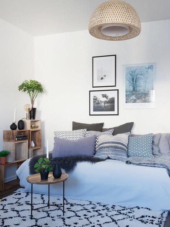 Pale woven bamboo pendant over a blue sofa