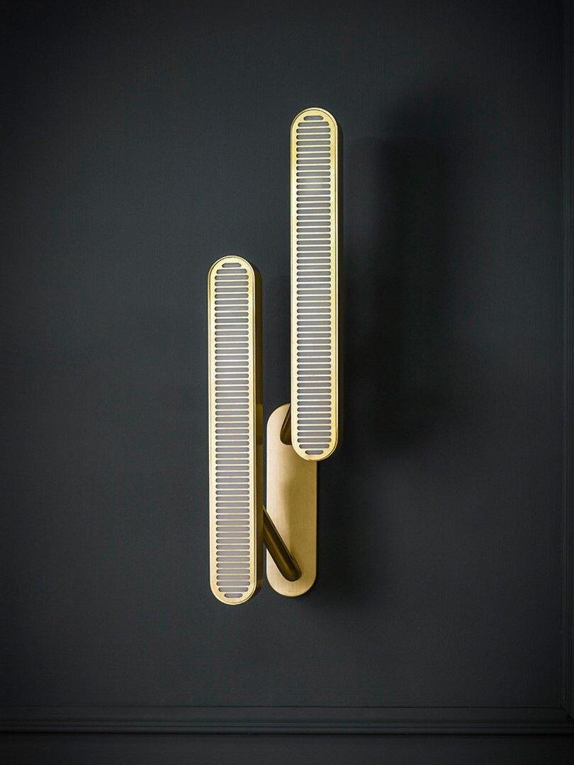 Unlit staggered vertical grille bars with pale slots and gold-tone edges on a common backplate against Dark Gray
