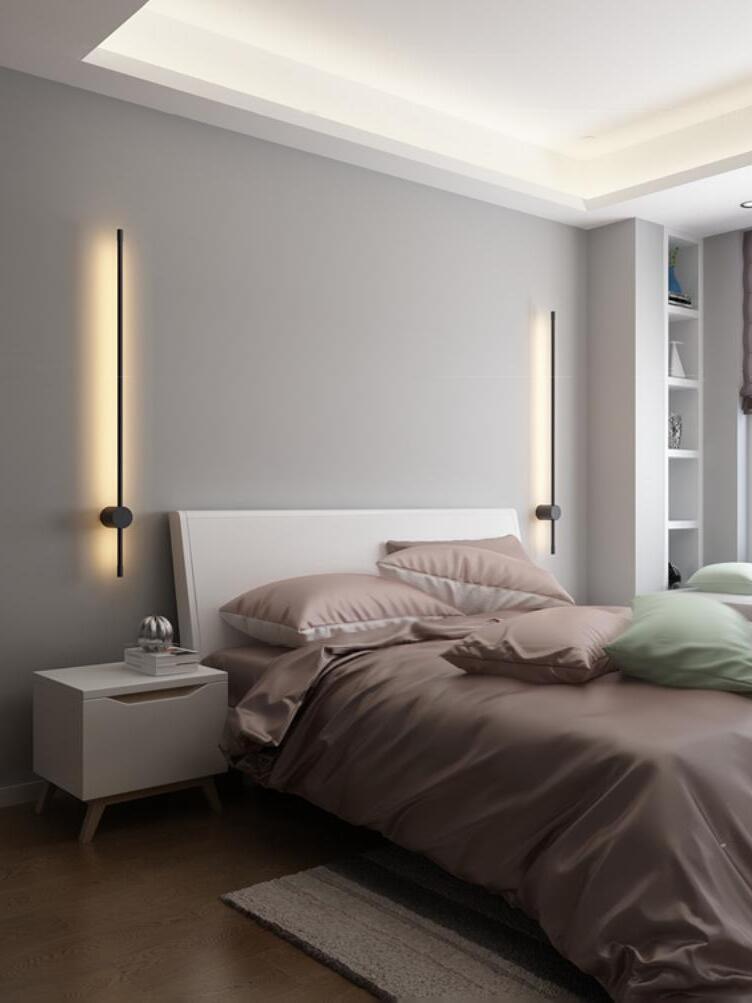 Two vertical wall lights flanking a bed