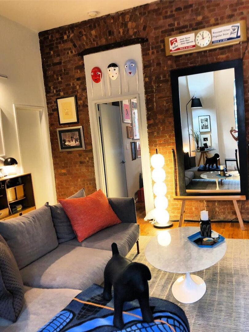 Illuminated globe lamp beside sofa and wall mirrors