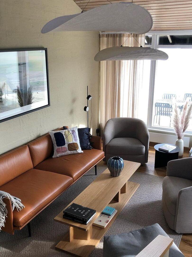 Cloud-like pendants above a lounge with brown sofa