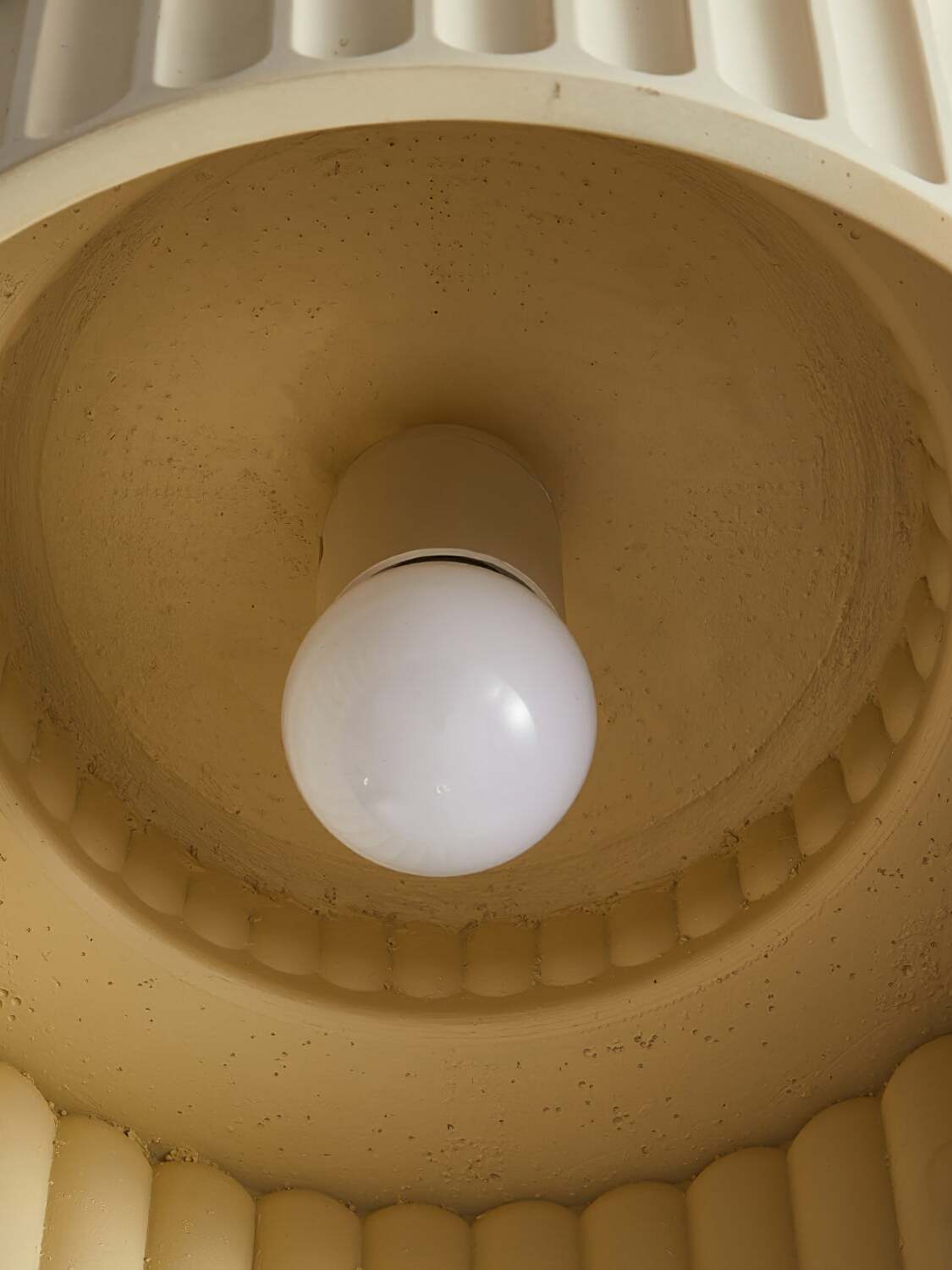 Interior underside of ribbed ceiling light with central bulb