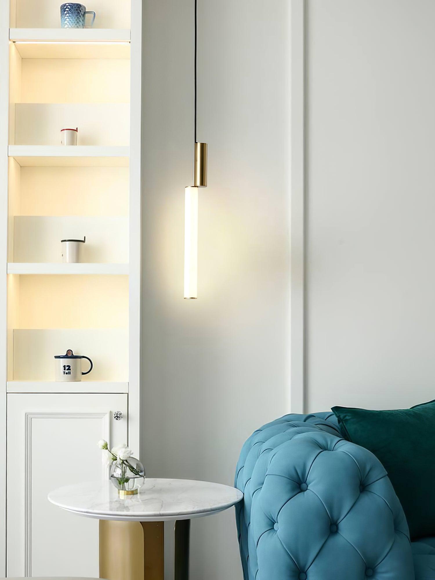 Single gold-top white tube pendant near turquoise sofa