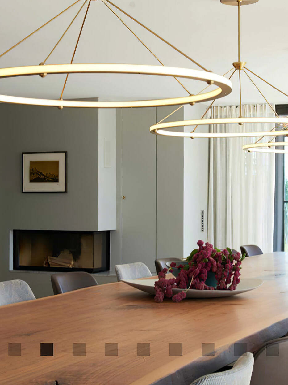 Multiple gold ring pendants above a long dining table