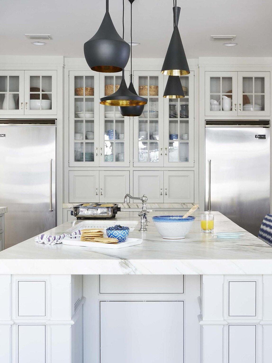Mixed black pendants in front of a glass-front cabinet