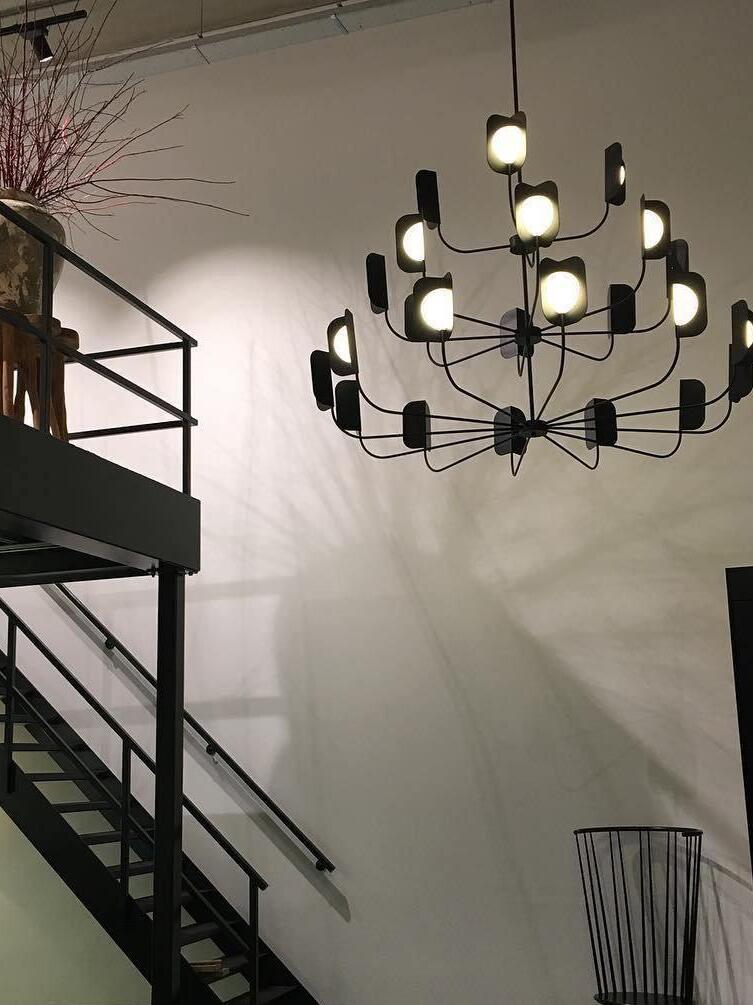 Tiered black chandelier beside a staircase