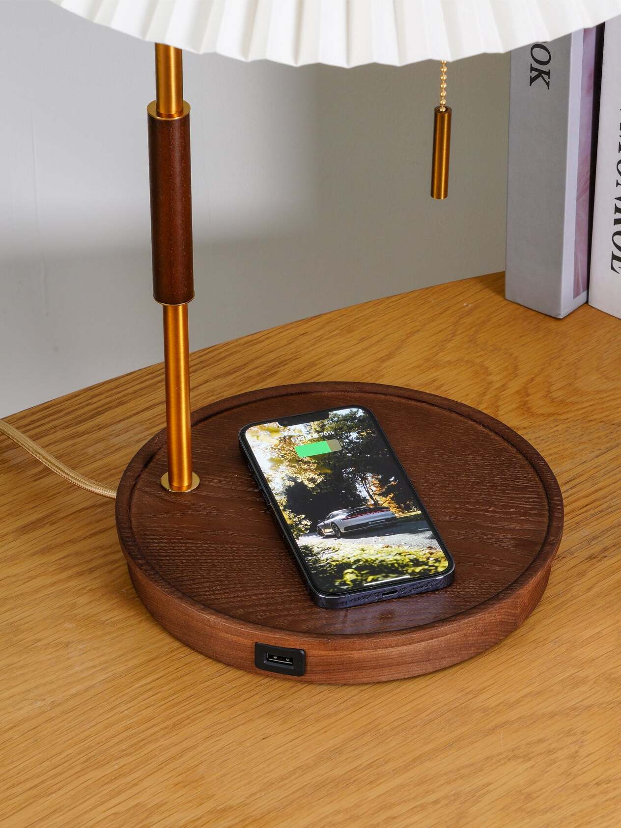 Close view of a phone on the recessed wooden lamp base, a front USB port and a hanging pull chain
