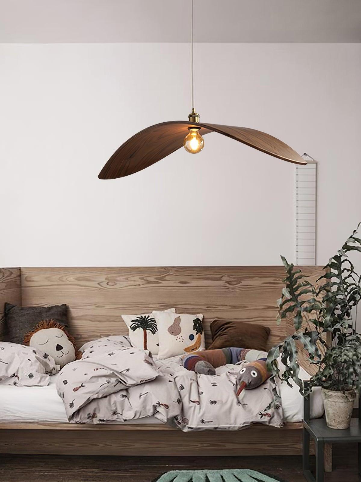 Curved wooden pendant above a cushioned bench with patterned pillows and a plant