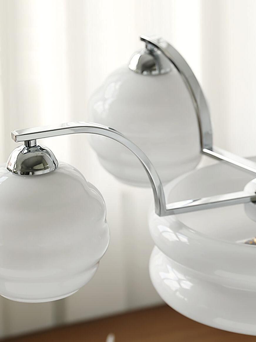 Close detail of chrome arms and White glass shade caps