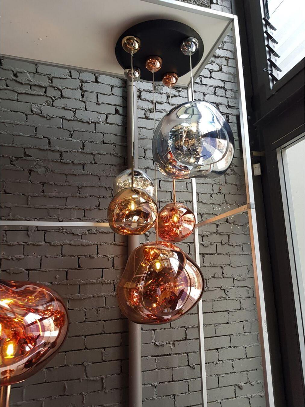 Mixed metallic-looking pendants near a brick wall