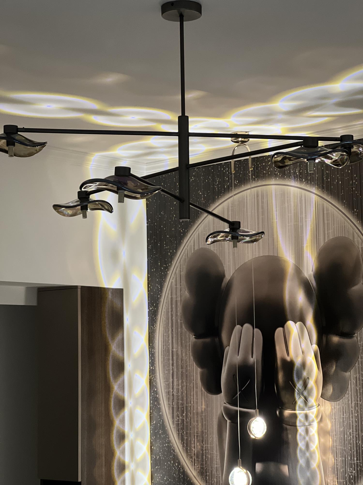 Calla chandelier near a patterned wall and ceiling reflections
