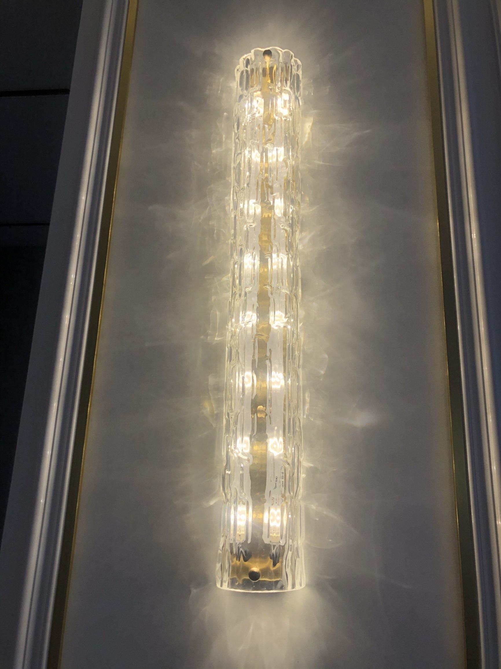 Elongated relief texture on illuminated clear glass wall light