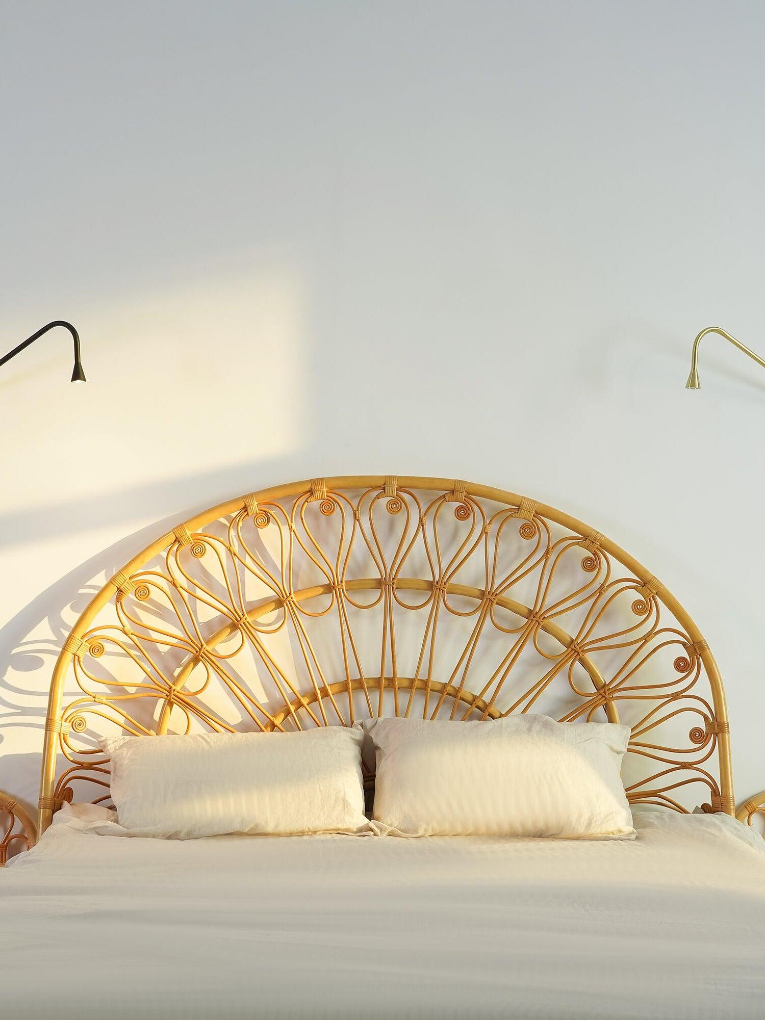 Black and Golden wall lights beside a bed