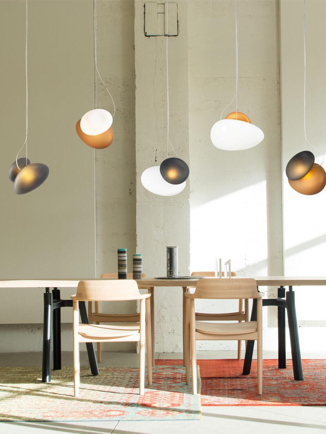 Different pebble glass pendants above a dining table
