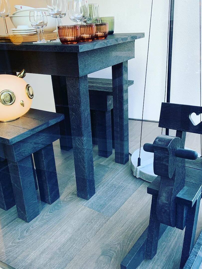 Cropped owl on lower furniture shelf near drink glasses and blue chair