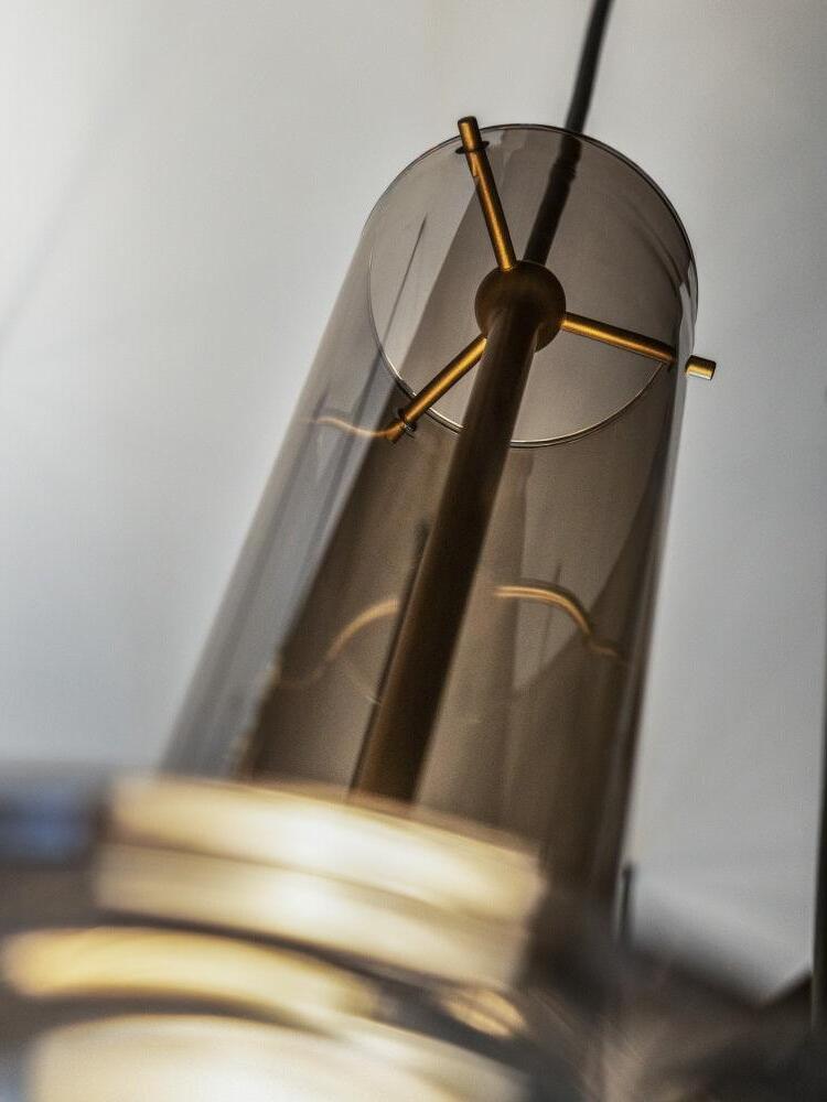 Close view of smoky glass upper rim, gold-tone central stem, round top joint and three cross-support pins