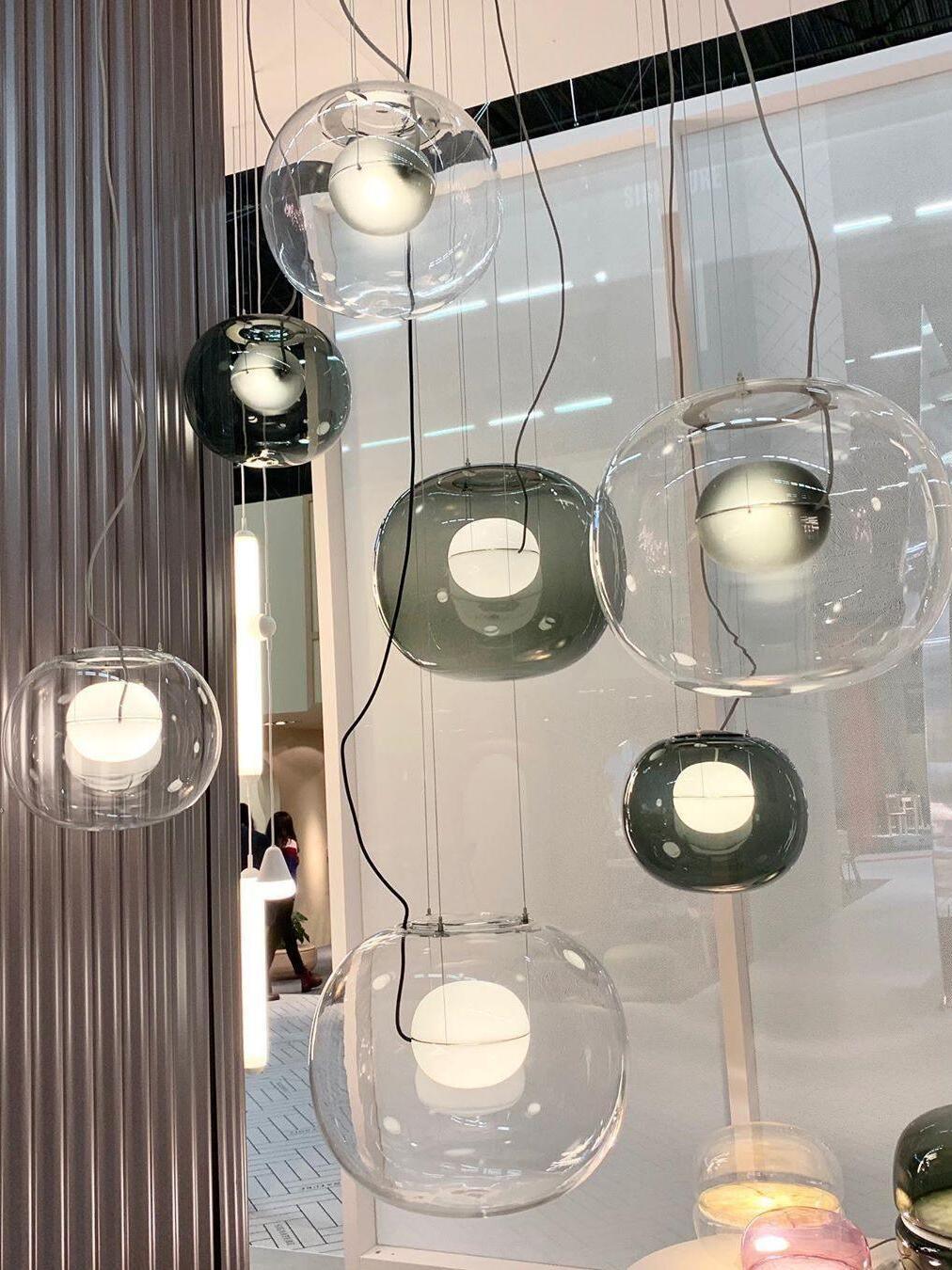 Display of clear and dark glass pendants at different heights