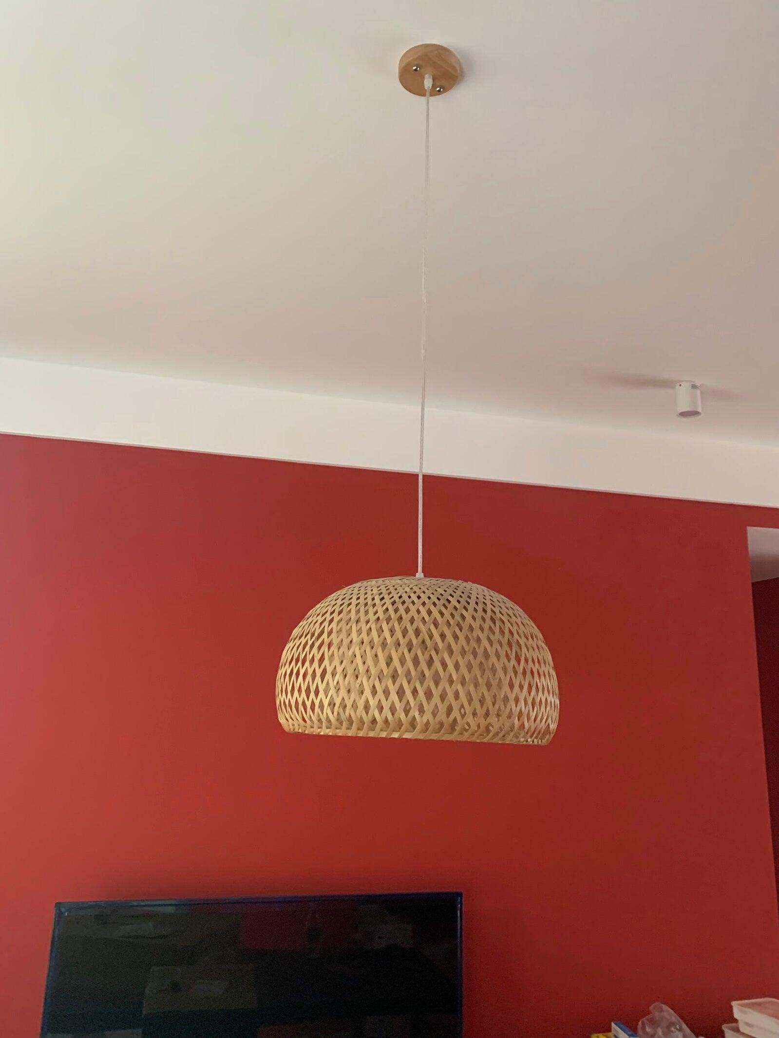 Bamboo basket shade against red wall above screen