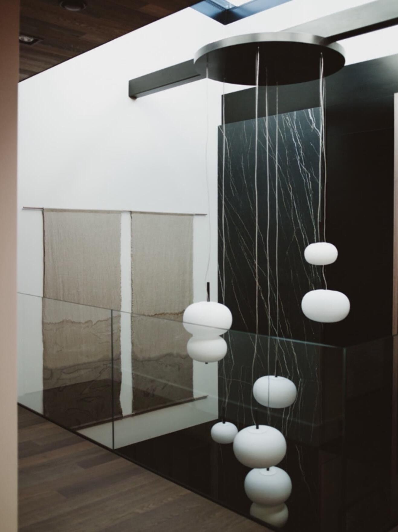 Long suspended globe arrangement in a gallery scene