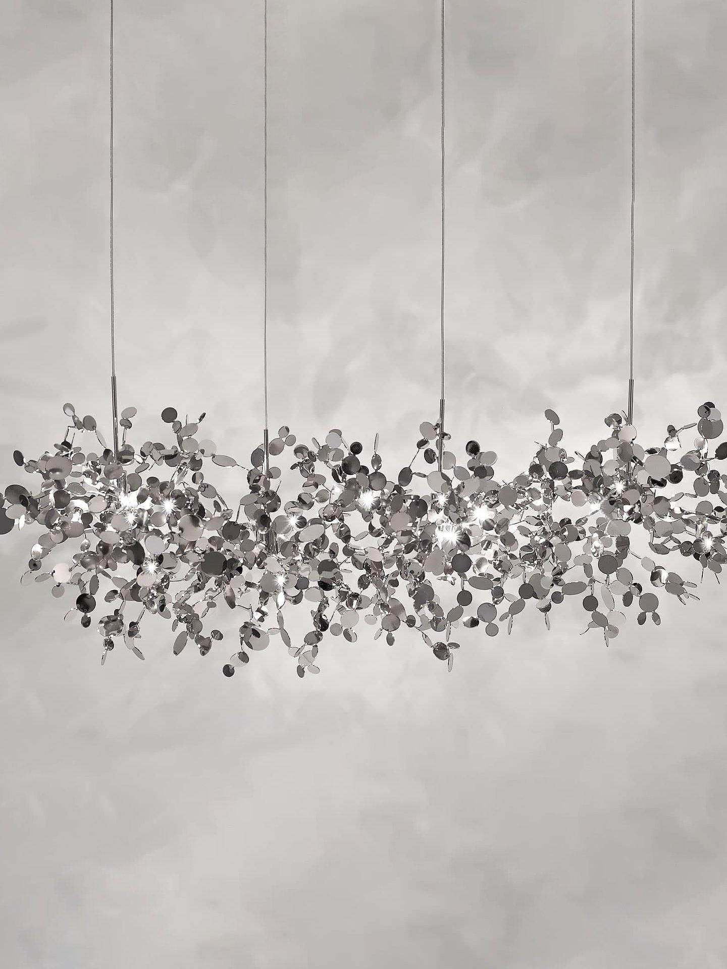 Long silver-toned disc chandelier on a plain grey background
