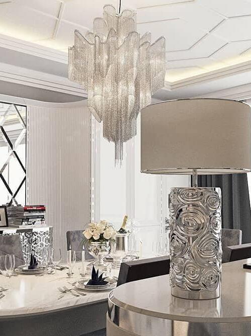 Tall silver-coloured chain chandelier near a mirror