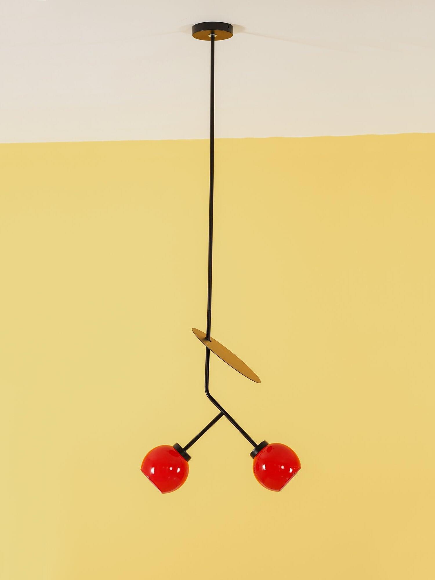 Cherry pendant suspended against a yellow wall