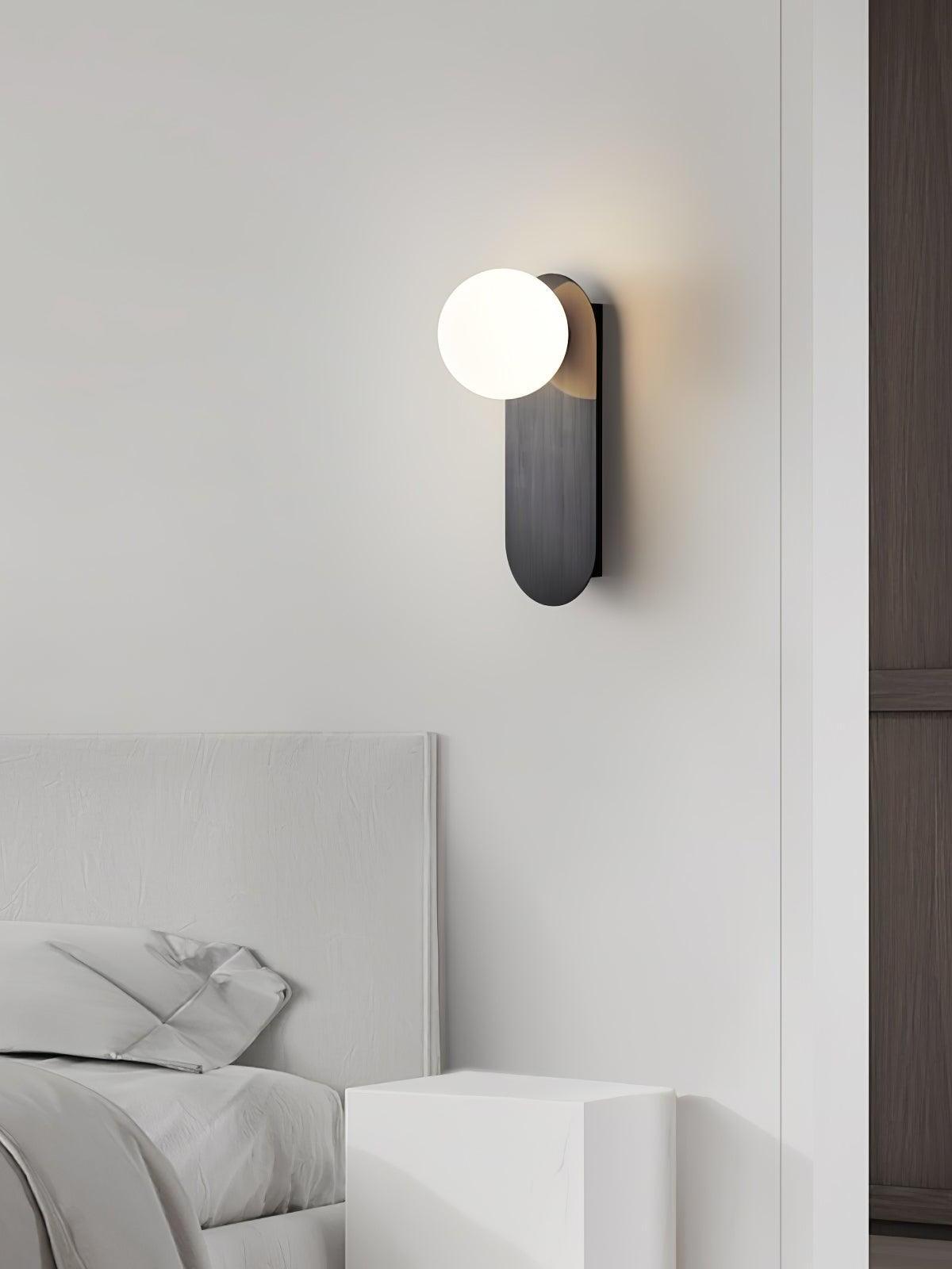 Black rounded-end plate and White globe beside a bed