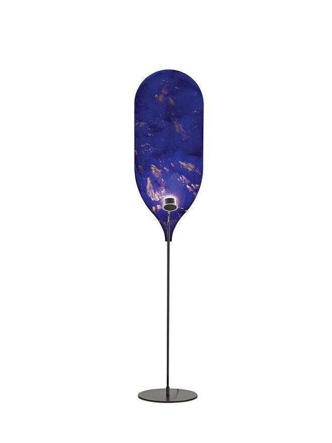 Deep blue rounded panel with gold-toned marks above black stem and circular base