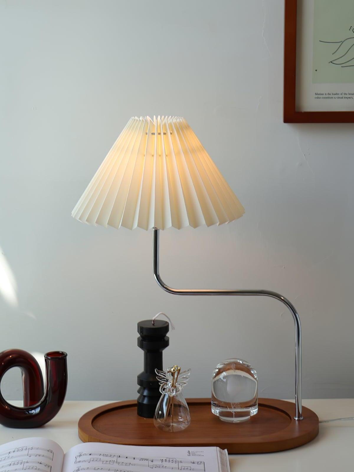 White pleated table lamp with small objects on base