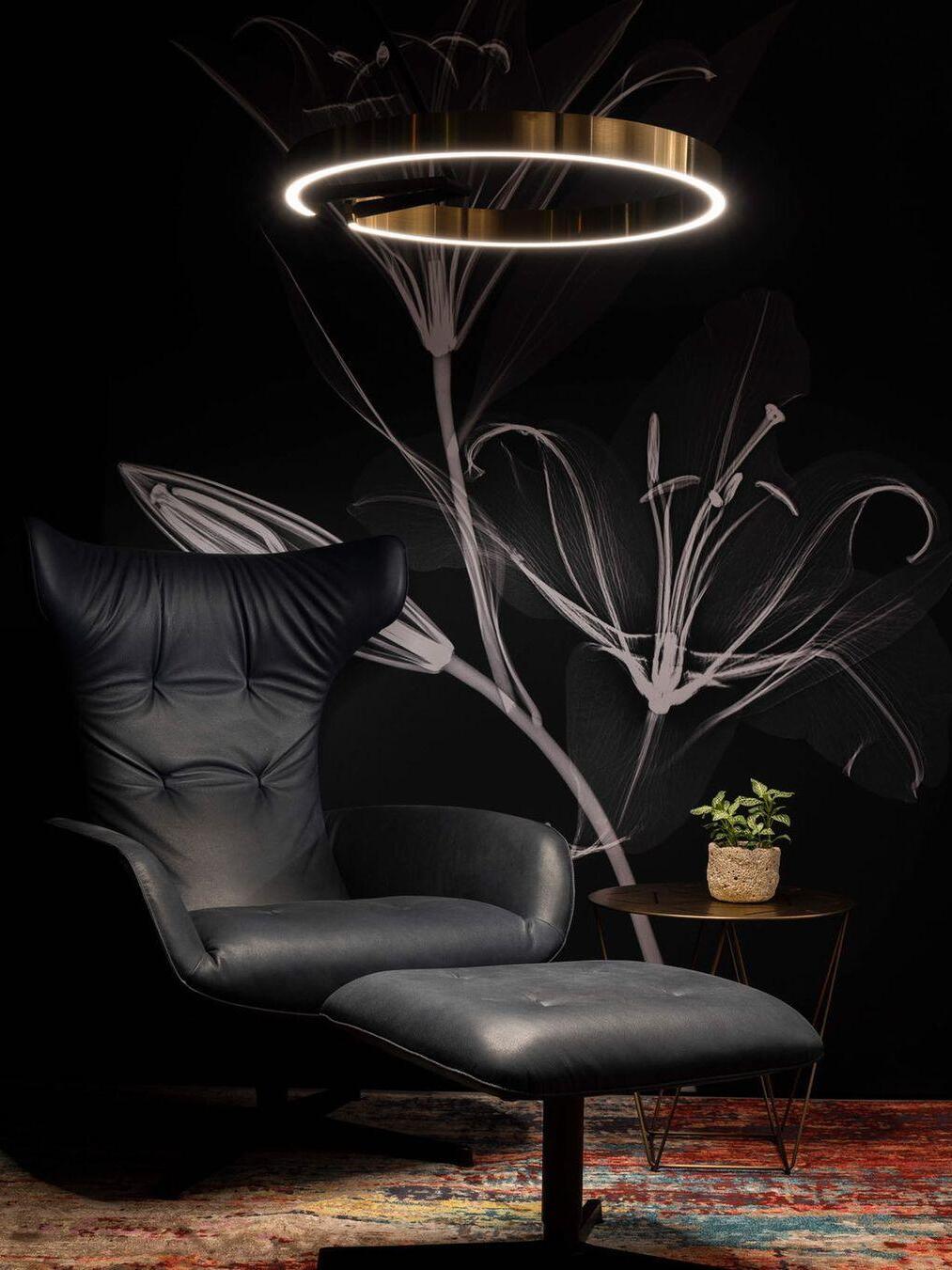 Illuminated ring above a black lounge chair