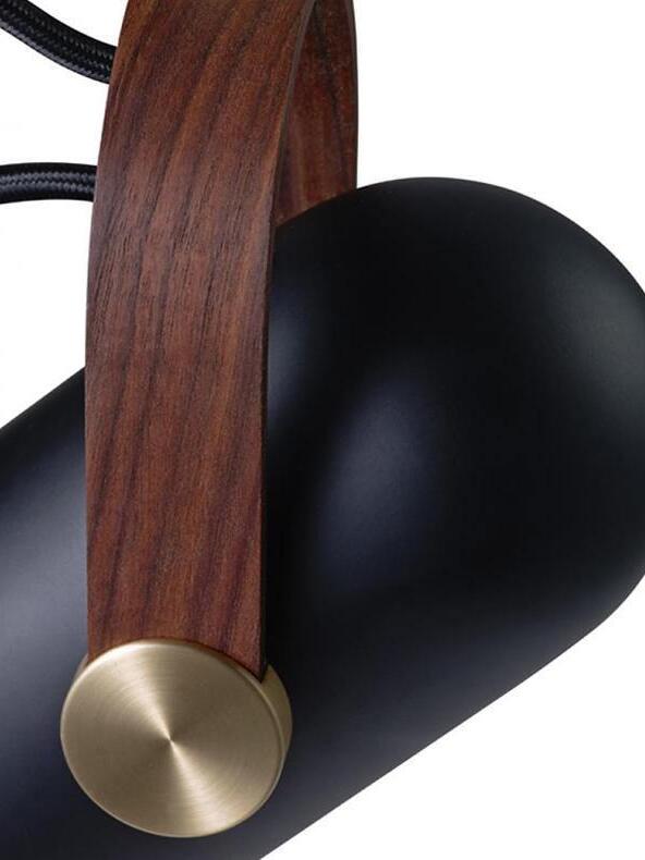 Detail of dark wood grain bracket and circular gold-tone pivot against the rounded black metal head