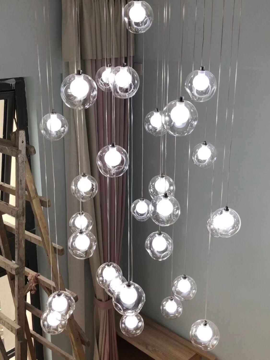 Glass globe lights suspended beside wood stair rail
