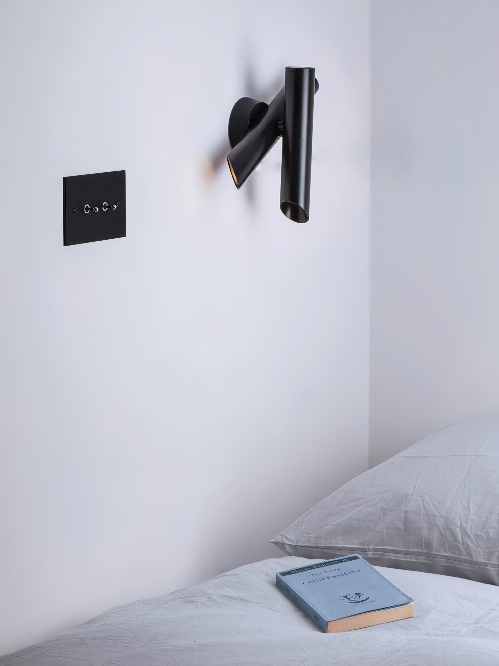 Black wall lamp by bed near wall switch
