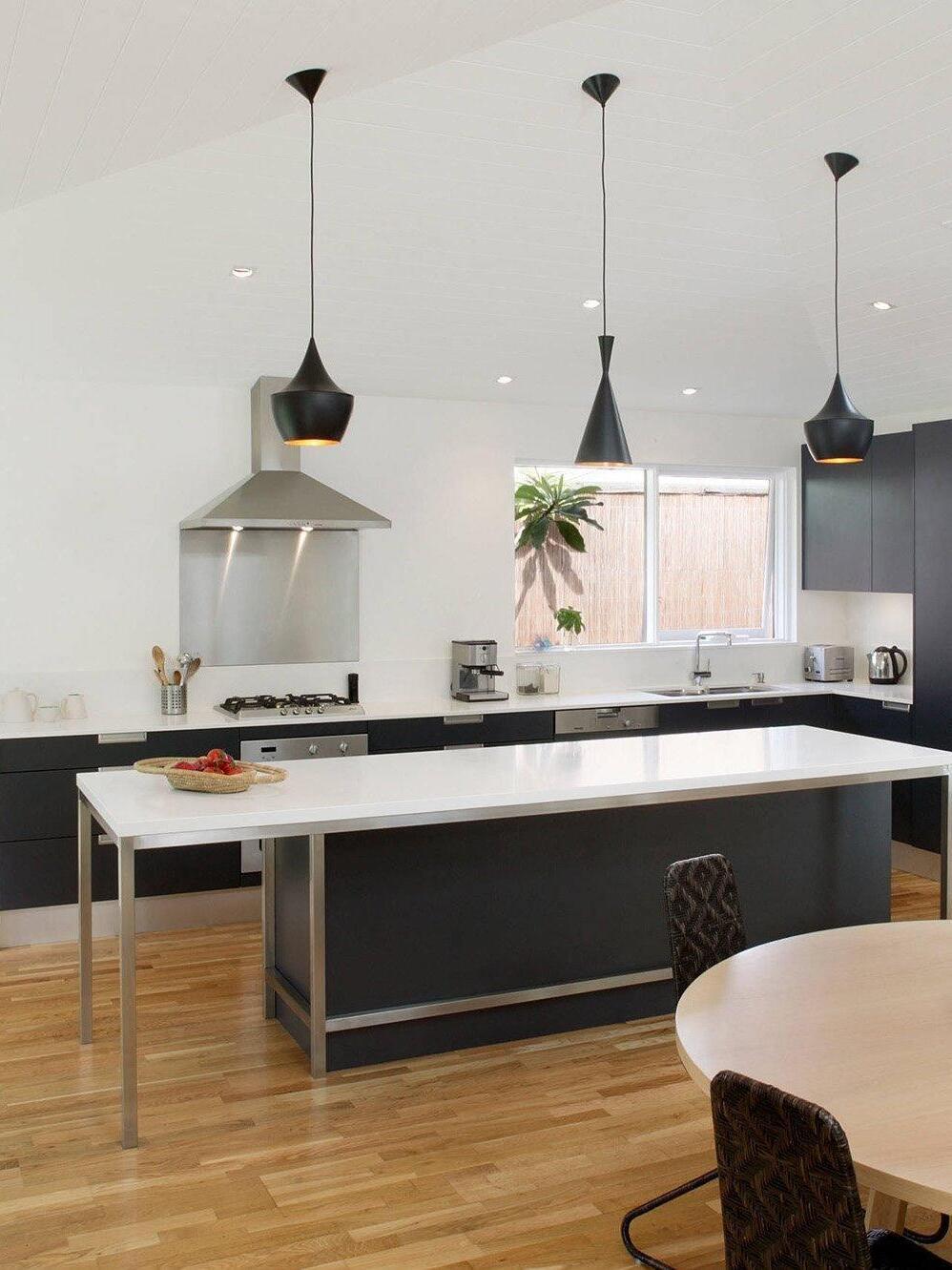 Three black shade shapes over a kitchen counter