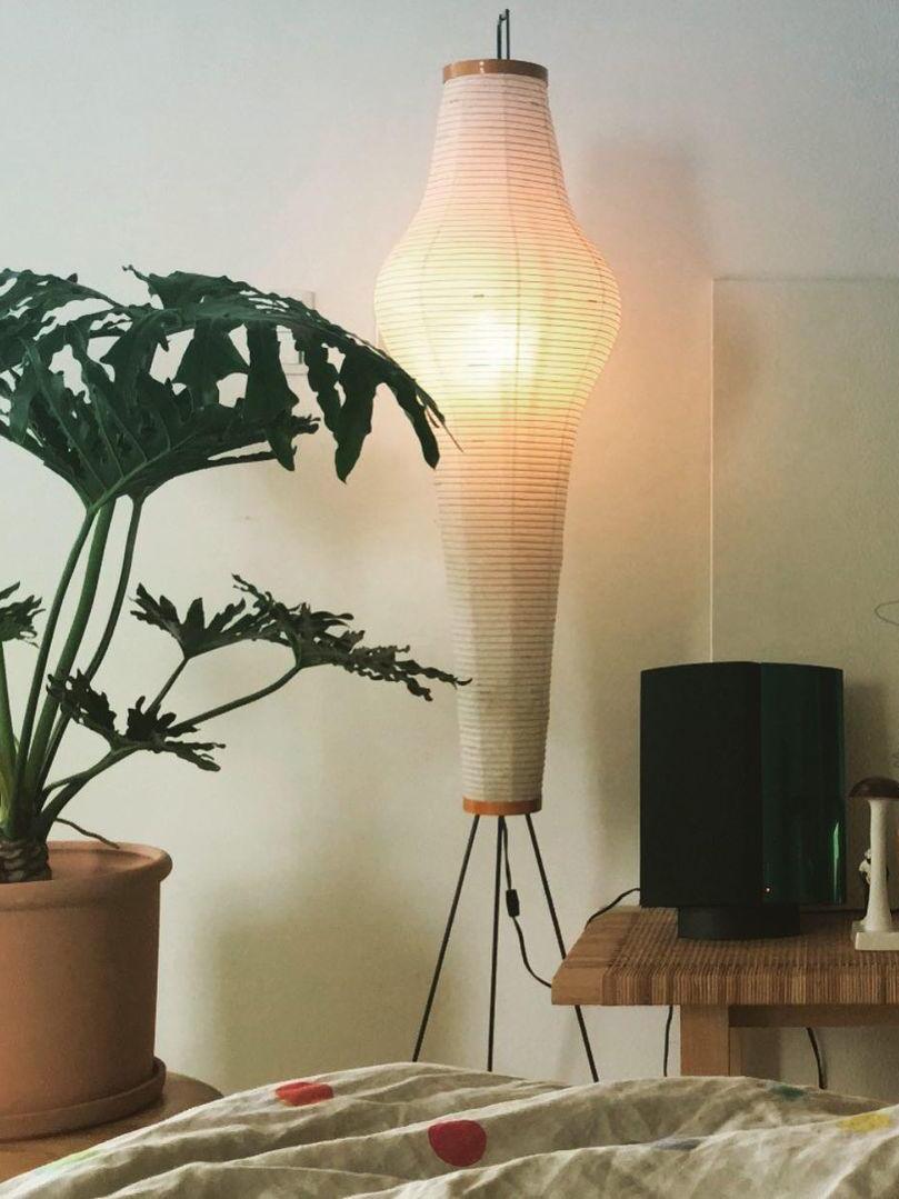 Tall tapered paper lamp near houseplant