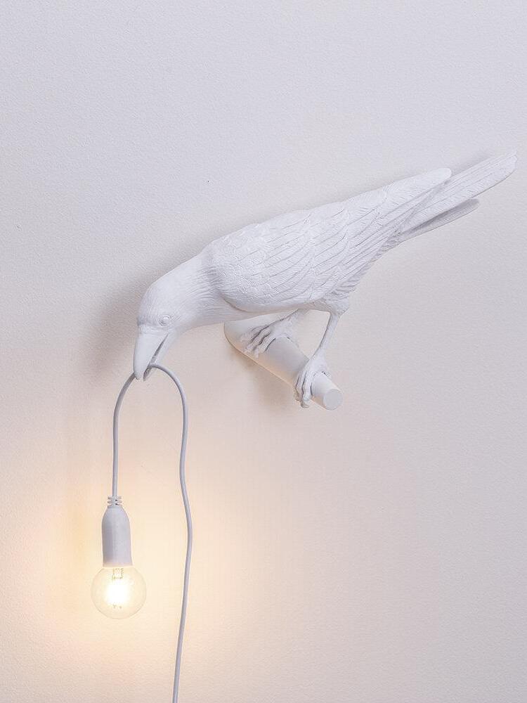 Repeated view of the white bird facing left with its lit hanging bulb and trailing cord