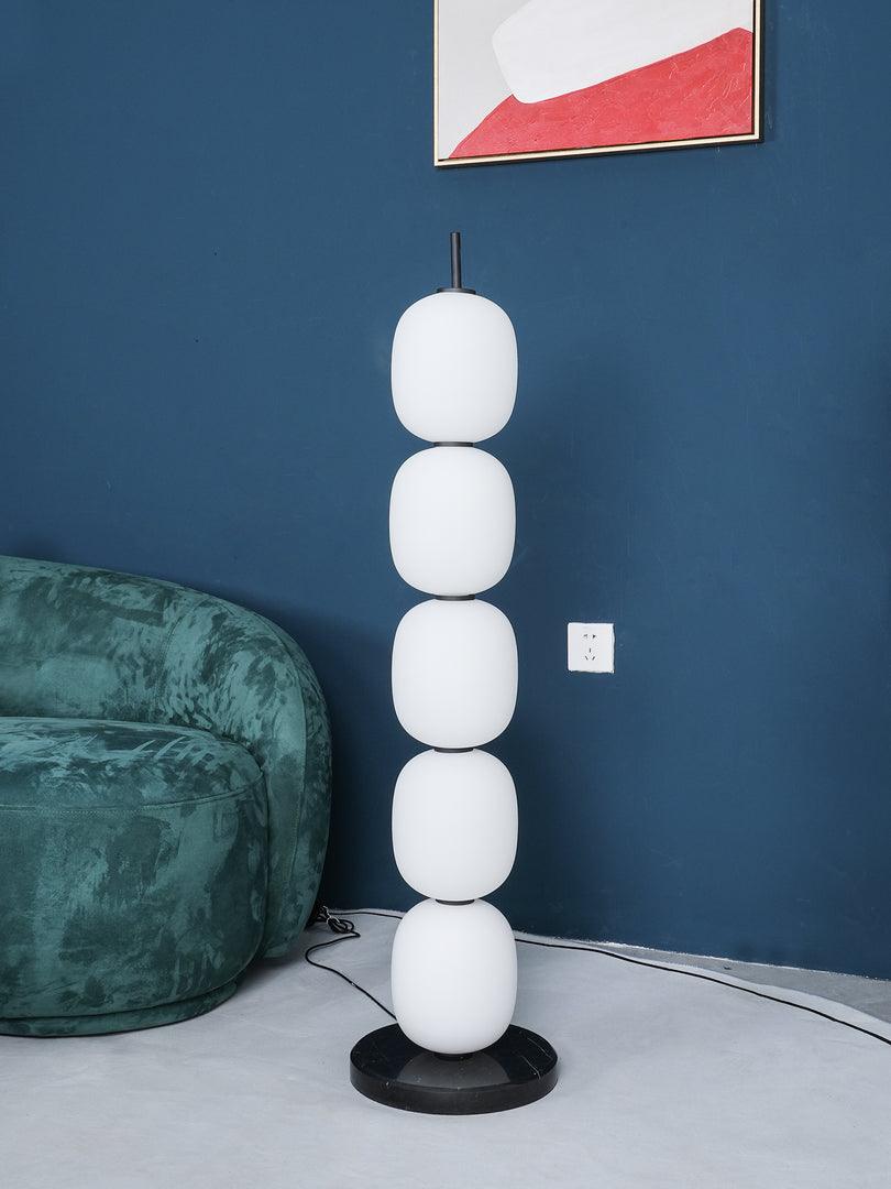 Unlit five-globe lamp against blue wall