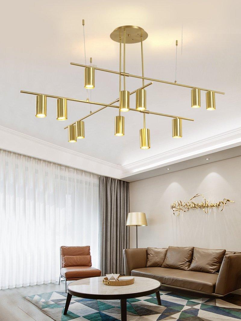 Gold-coloured geometric chandelier above a brown sofa
