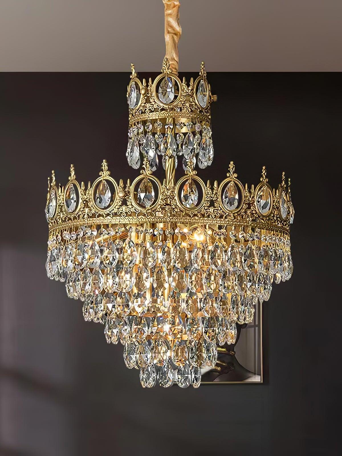 Broad crown-style crystal chandelier illuminated beneath a covered suspension in a dark room