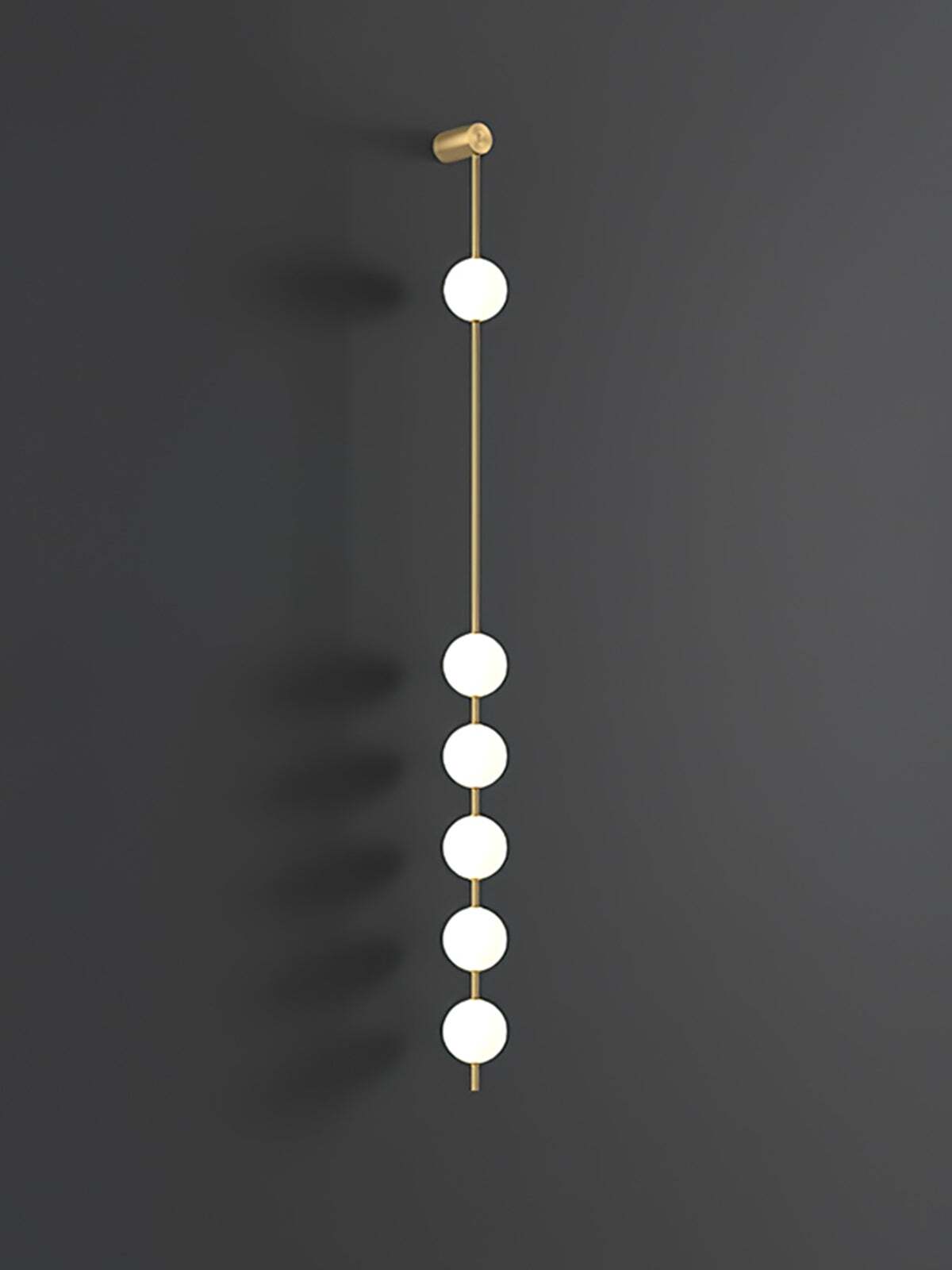 Enlarged six-globe wall lamp with lit white spheres on a gold-colour rod against dark grey