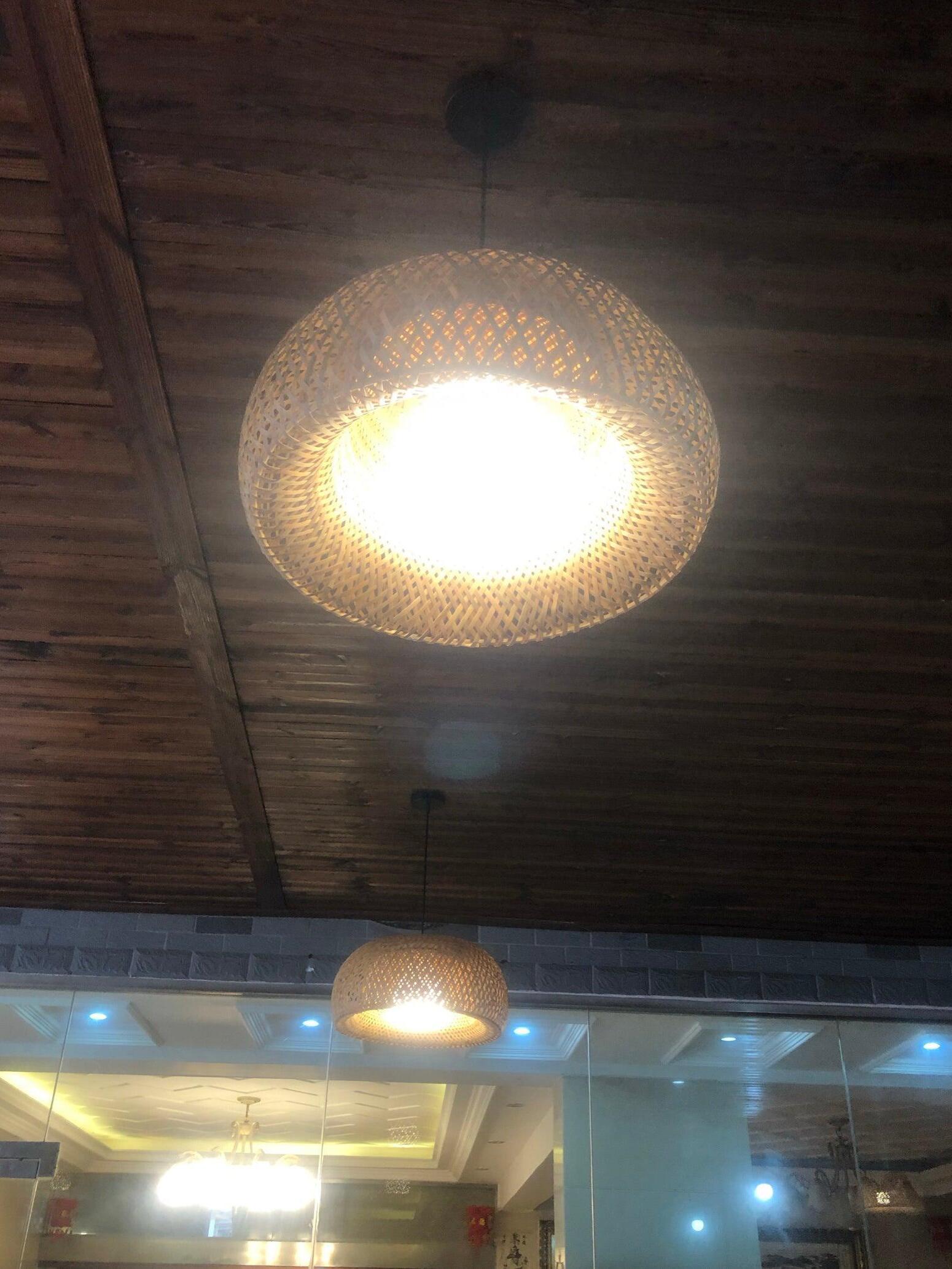 Bright underside of basket pendant under timber ceiling