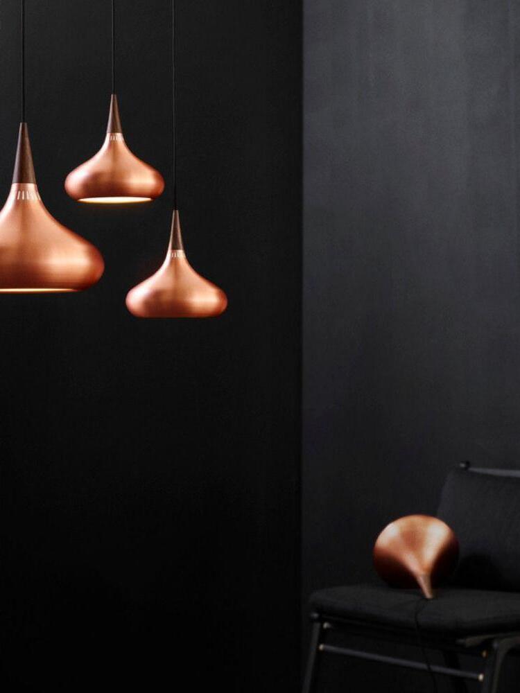 Group of Copper pendants against a dark wall